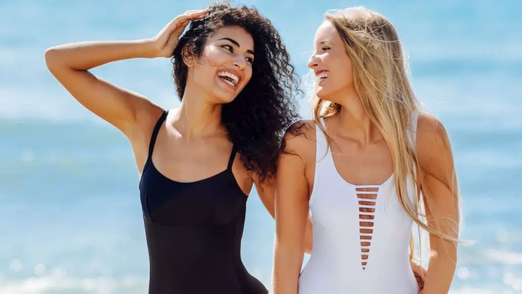 Light tanned girls laughing on the beach