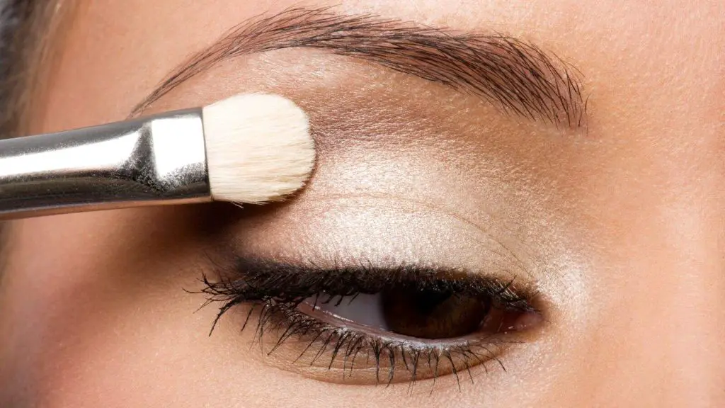 Brown skinned girl applying eyeshadow