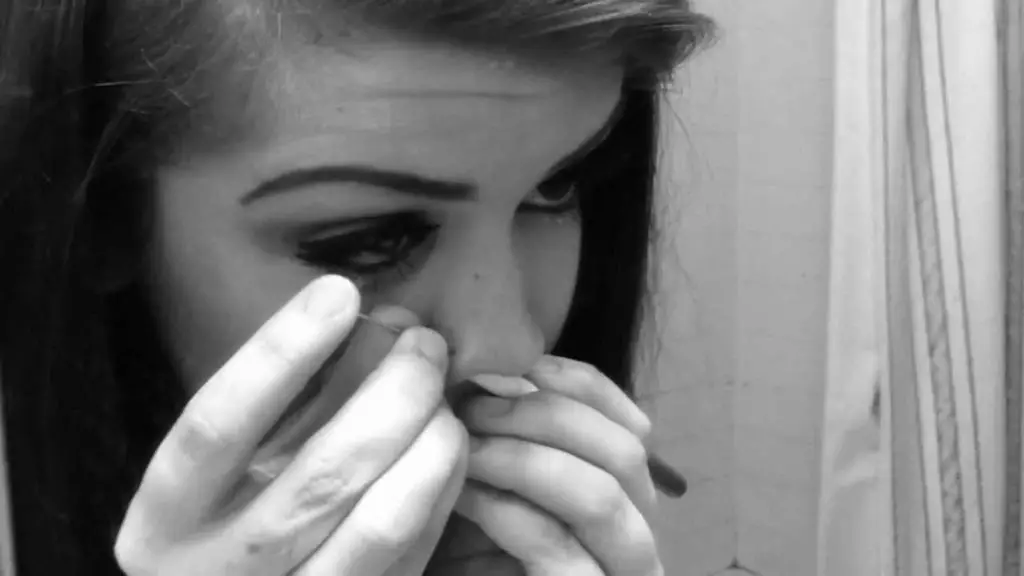 Woman piercing her own nose with sterile needle
