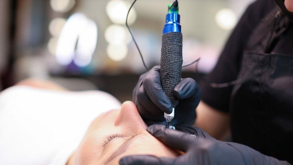 Tattoo artist making tattoo with tattoo pen