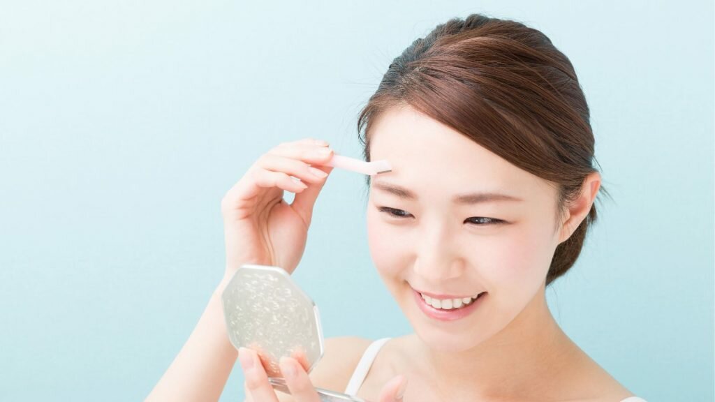 Woman using an eyebrow razor