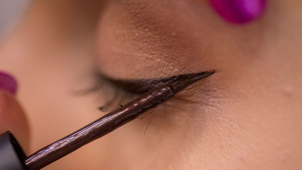 Woman applying eye liner